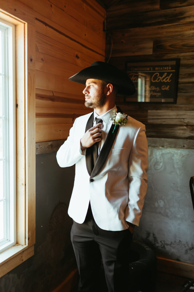 groom getting ready for his classy western wedding in Kansas