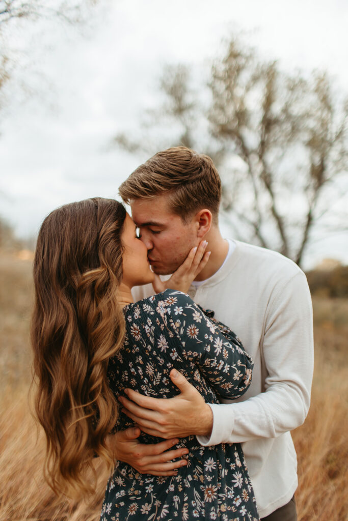 In the soft, creamy light of the setting sun, a couple shares a tender moment, beautifully preserved in their engagement photos.