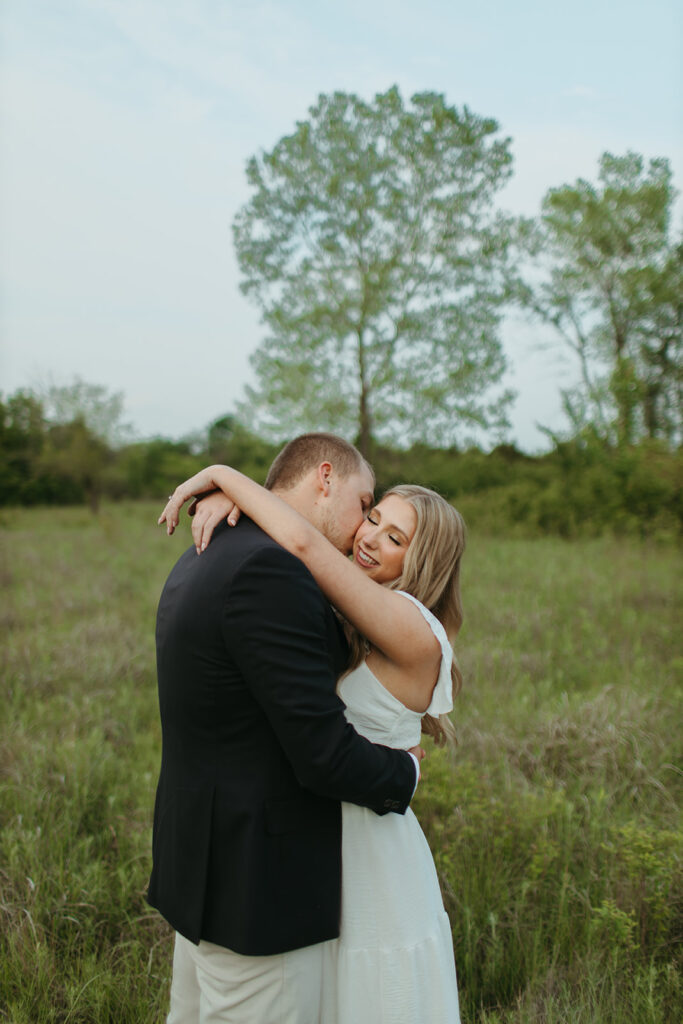 man and woman embrace in a green flowing meadow