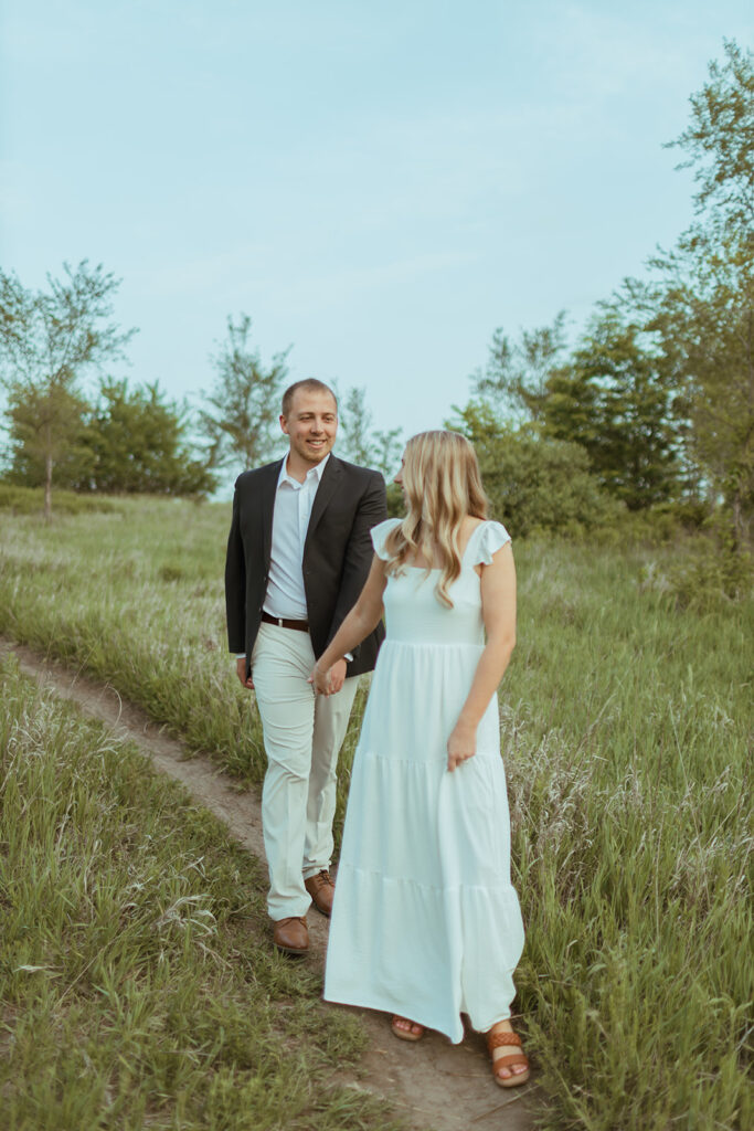 man and woman walking down dirt path during their engagement session