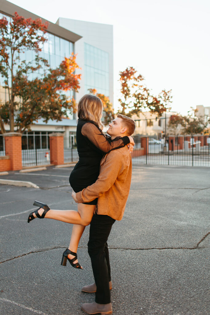 man picks up woman for their engagement photos