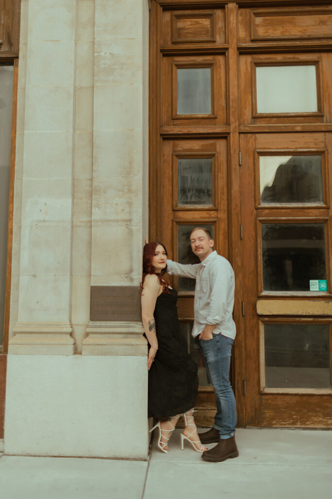 couple posing outside of a downtown building