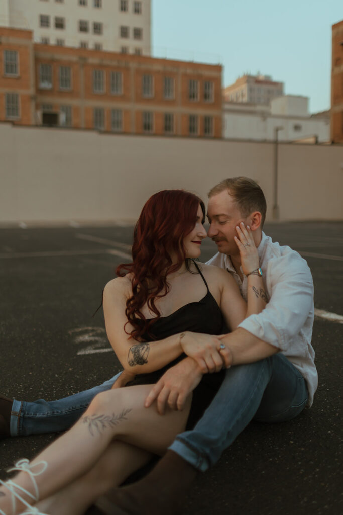 couple sitting on a parking garage rooftop