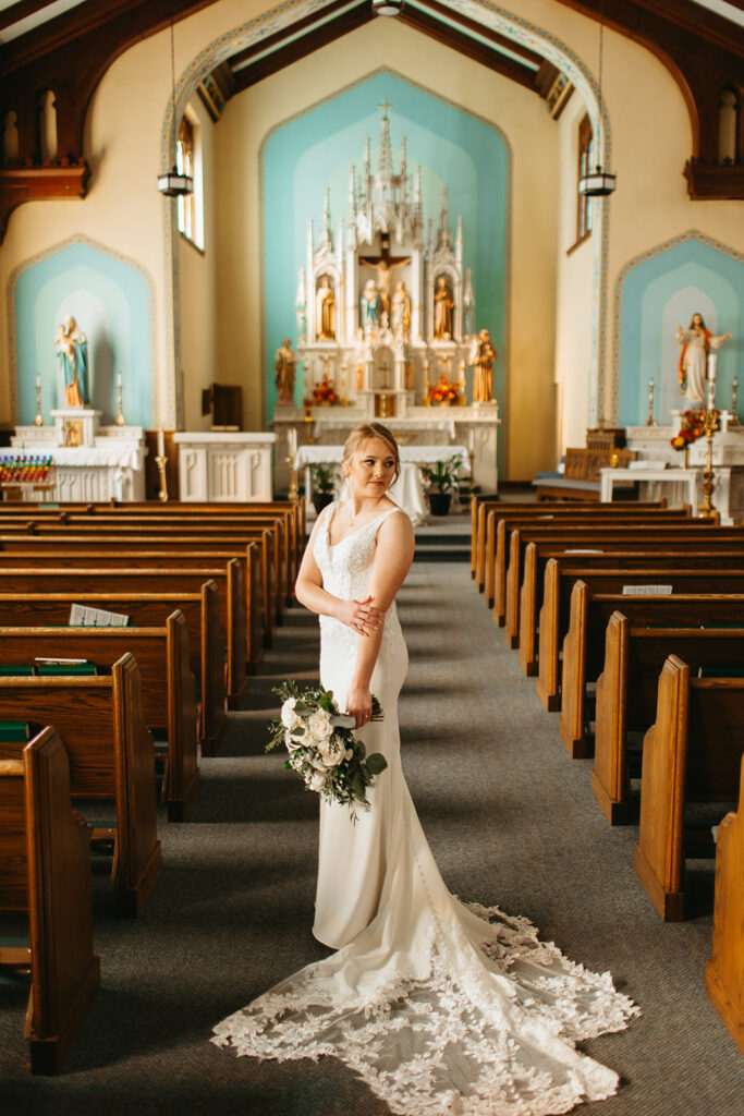 bride poses in the wedding ceremony aisle