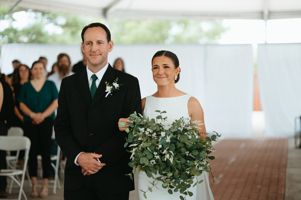 Father walking the bride down the aisle at the brick and mortar venue in Wichita, Kansas