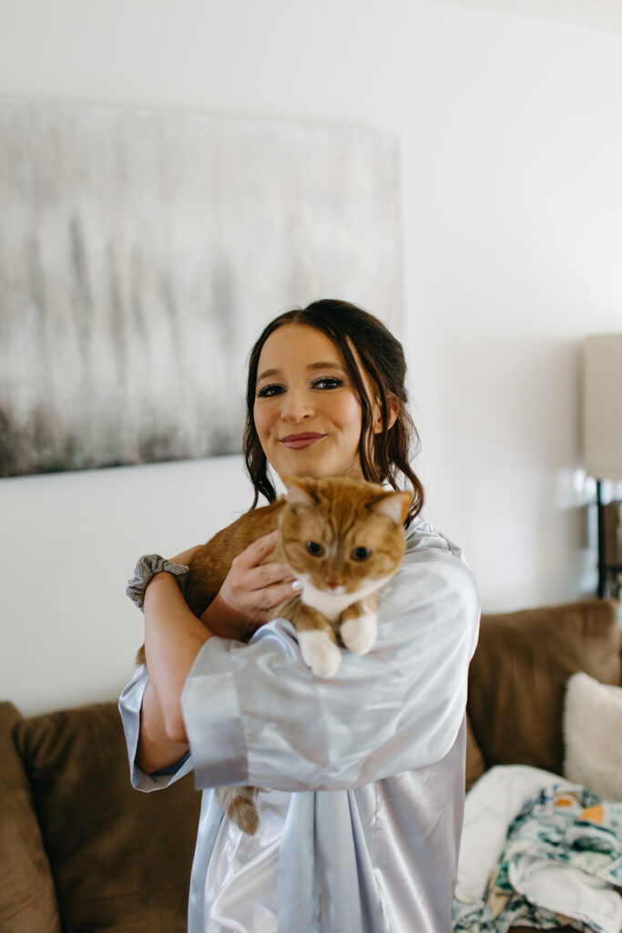 Bride holds her cat in her home while getting ready for their Wichita wedding ceremony