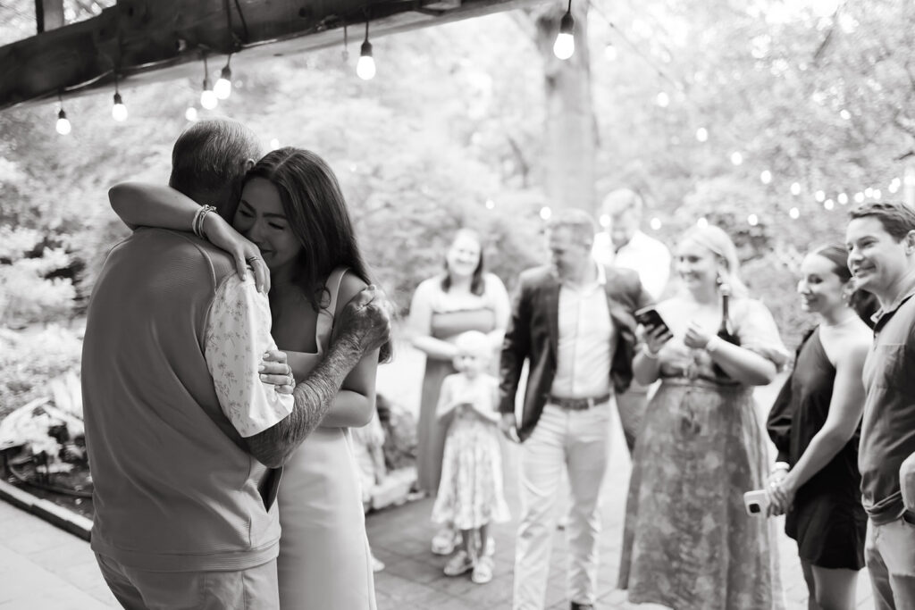 Woman hugs her father in an emotional moment during her surprise proposal photoshoot