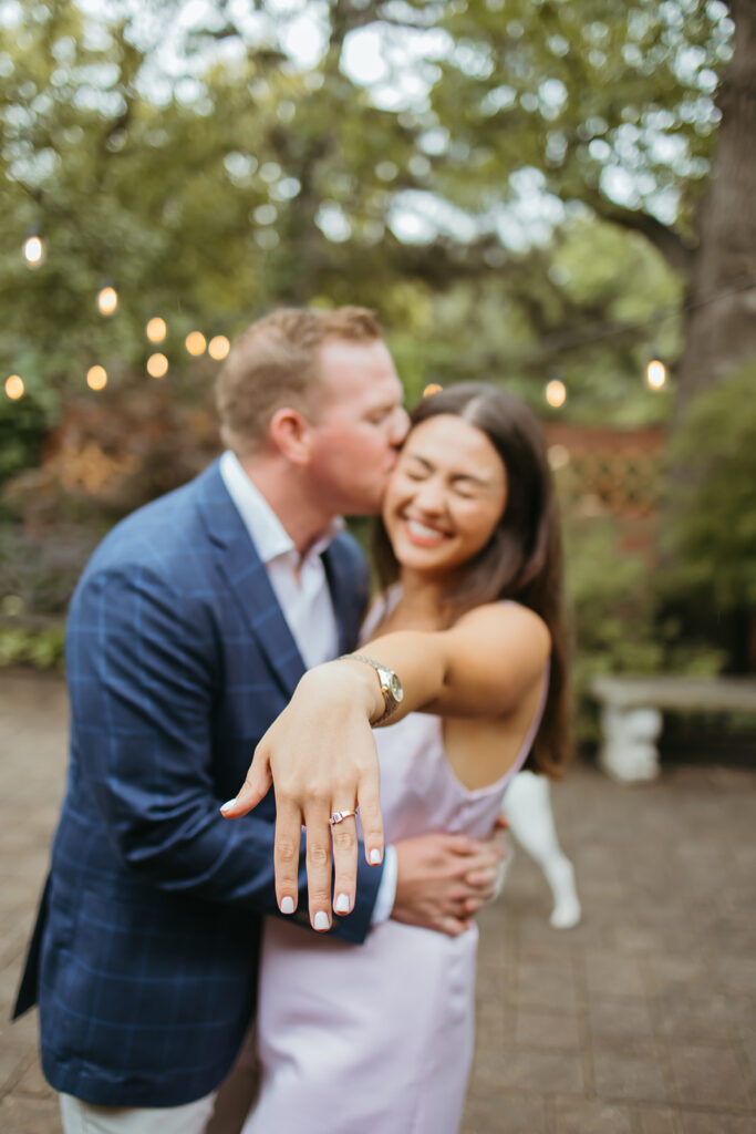 Woman puts out her ring hand excitedly after their emotional surprise proposal