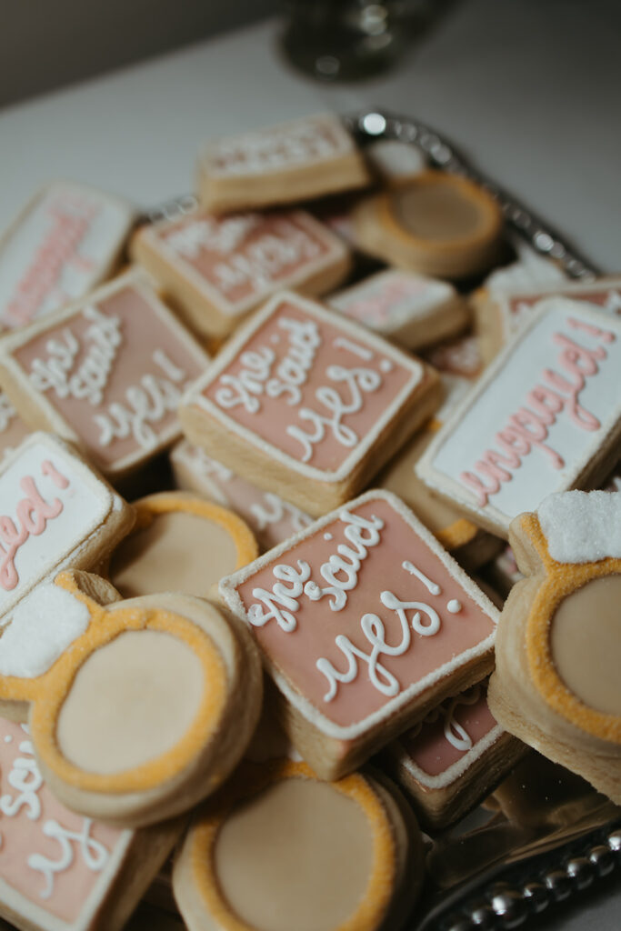 Sugar cookies decorated as rings and "she said yes!"